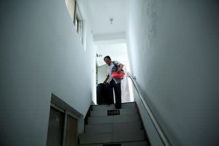 Pan carries his belongings as he prepares to check out of the accommodation where some patients and their family members stay while seeking medical treatment in Beijing, China, June 23, 2016. REUTERS/Kim Kyung-Hoon