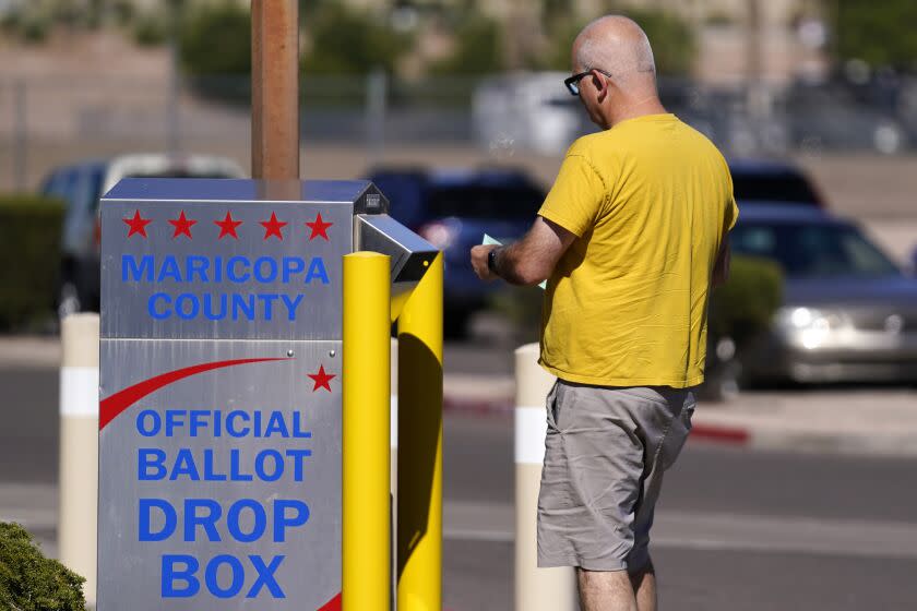 A voter places a ballot in an election voting drop box in Mesa, Ariz., Friday, Oct. 28, 2022. (AP Photo/Ross D. Franklin)