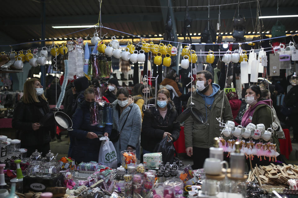 Bulgarian tourists shop at a bazaar in Edirne, near Bulgaria border, in Turkey, Friday, Dec. 24, 2021. Turkey's government and central bank have taken a series of complex steps in recent weeks to prop up a beleaguered economy crippled by skyrocketing consumer prices, instead of ending a much-criticized plan to cut interest rates. (AP Photo/Emrah Gurel)