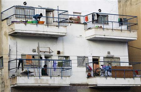 African migrants stand on their balconies at an apartment block in south Tel Aviv July 17, 2013. REUTERS/Amir Cohen