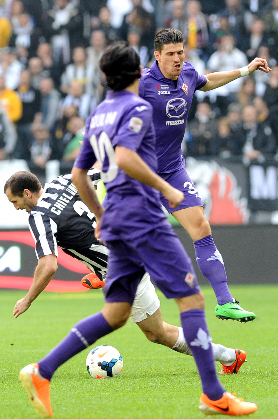 Fiorentina's Mario Gomez challenges the ball with Juventus defender Giorgio Chiellini during a Serie A soccer match between Juventus and Fiorentina at the Juventus stadium, in Turin, Italy, Sunday, Mar. 9, 2014. (AP Photo/Massimo Pinca)