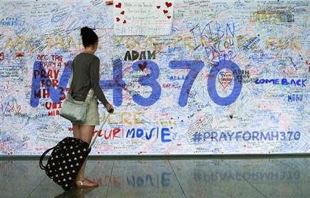 A woman looks at messages of support left for family members and passengers onboard the missing Malaysia Airlines Flight MH370 at the Kuala Lumpur International Airport (KLIA) in Sepang, outside Kuala Lumpur March 18, 2014. REUTERS/Samsul Said
