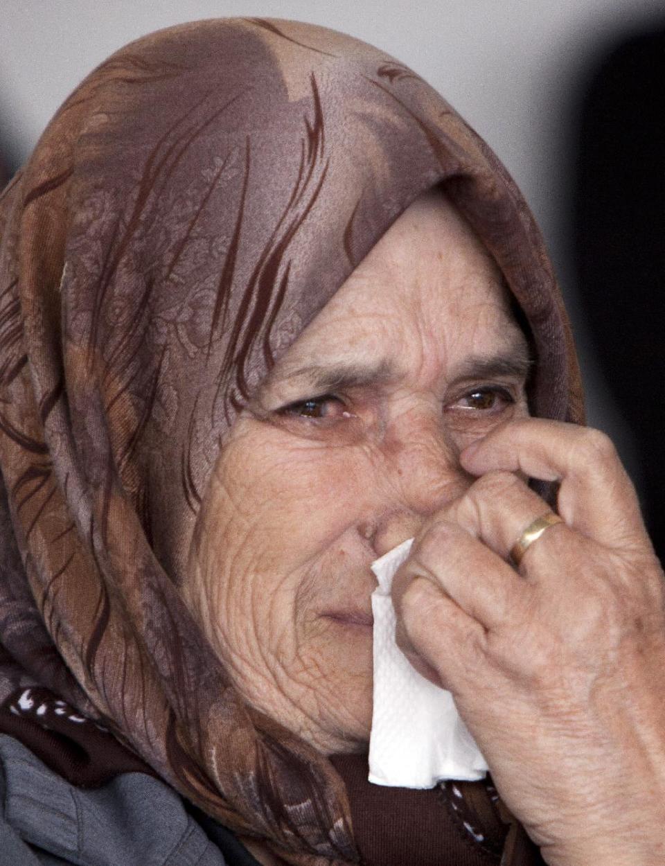 A relative weeps as 46 coffins, draped with Albanian flags, containing the remains of ethnic Albanians killed during the 1998-99 Kosovo war, are handed over to family members in capital Pristina on Monday, March 24, 2014. The victims were killed in two separate rampages by Serbs forces in western Kosovo just days after NATO began a bombing campaign to stop Serbia’s onslaught on separatist ethnic Albanians on March 1999. (AP Photo/Visar Kryeziu)