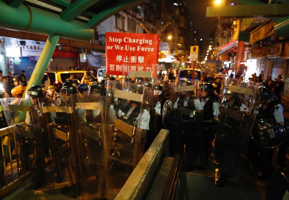 Police move out from the Shum Shui Po police station to confront protesters in Hong Kong on Wednesday, Aug. 14, 2019. German Chancellor Angela Merkel is calling for a peaceful solution to the unrest in Hong Kong amid fears China could use force to quell pro-democracy protests.(AP Photo/Vincent Yu)