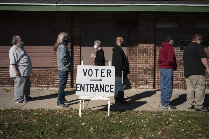 FILE - Voters wait in line outside a polling center on Election Day, in Kenosha, Wis. in this Nov. 3, 2020 file photo. Wisconsin Republicans are working to discredit the bipartisan system they created to run elections in the state after President Joe Biden narrowly won last year's presidential race, making the political battleground state the latest front in the national push by the GOP to exert more control over elections. (AP Photo/Wong Maye-E, File)