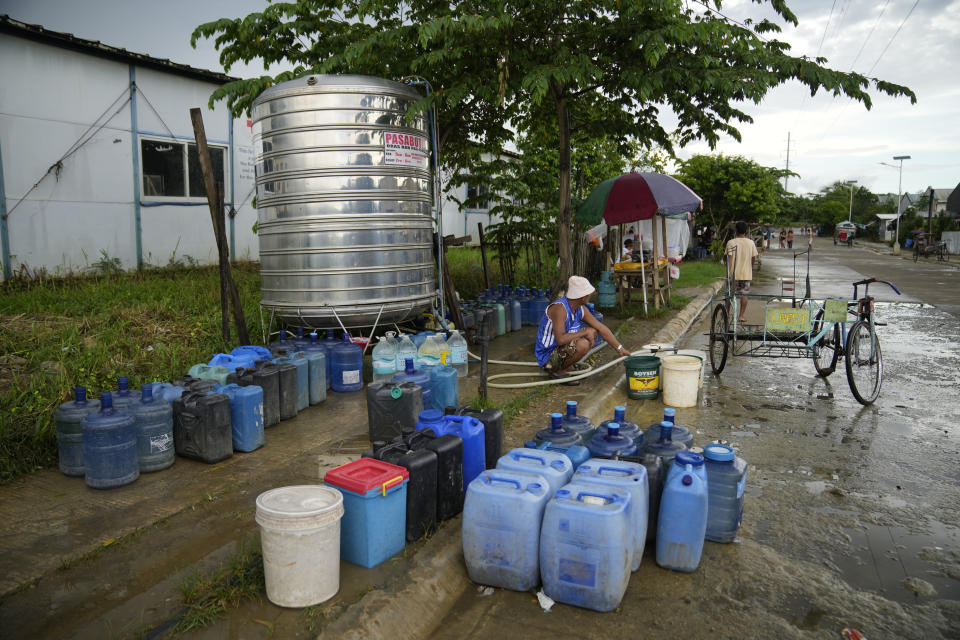 Residents collect water at a relocation site for victims of Typhoon Haiyan in Tacloban, central Philippines on Monday, Oct. 24, 2022. (AP Photo/Aaron Favila)