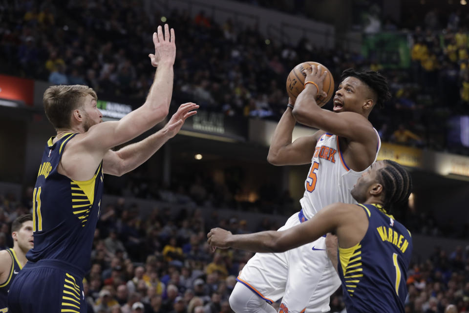 New York Knicks' Dennis Smith Jr. (5) puts up a shot against Indiana Pacers' T.J. Warren (1) and Domantas Sabonis (11 during the first half of an NBA basketball game, Saturday, Feb. 1, 2020, in Indianapolis. (AP Photo/Darron Cummings)