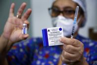 FILE - In this Feb. 22, 2021, file photo, a nurse holds up the Sputnik V vaccine for COVID-19 at the National Hospital as vaccinations start in Itaugua, Paraguay. Russia’s boast in August that it was the first country to authorize a coronavirus vaccine led to skepticism because of its insufficient testing on only a few dozen people. Now, with demand growing for the Sputnik V, experts are raising questions again, this time over whether Moscow can keep up with all the orders from countries that want it. (AP Photo/Jorge Saenz, File)