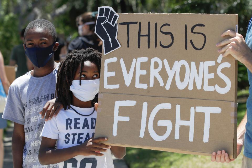 Young demonstrators hold a sign, June 9, 2020, in Culver City, Calif. during a student-led protest over the death of George Floyd who died May 25 after he was restrained by Minneapolis police.