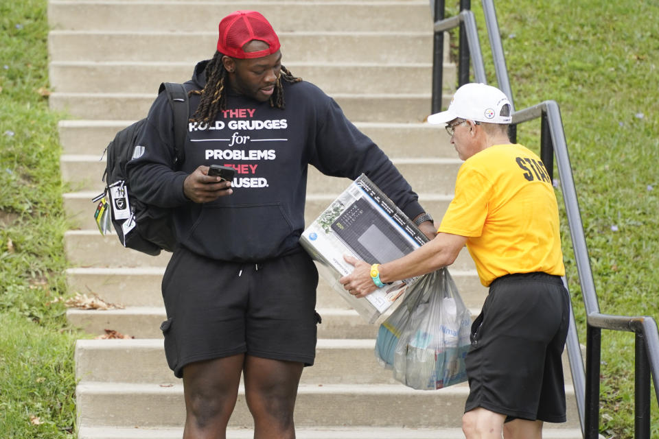 New Pittsburgh Steelers defensive tackle, Larry Ogunjobi, left, gets some help as he arrives for NFL football training camp in Latrobe, Pa., Tuesday, July 26, 2022. (AP Photo/Keith Srakocic)