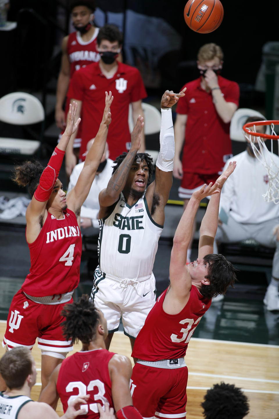 Michigan State's Aaron Henry (0) shoots against Indiana's Khristian Lander (4), Trey Galloway (32), and Trayce Jackson-Davis (23) during the first half of an NCAA college basketball game, Tuesday, March 2, 2021, in East Lansing, Mich. (AP Photo/Al Goldis)