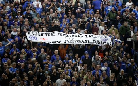 Portsmouth fans hold aloft a banner reading: "You're going home in a Pompey ambulance" in the Fratton End - Credit: Robin Jones/Getty