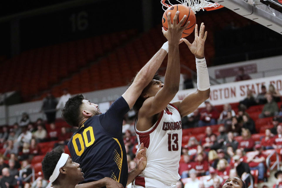 Washington State forward Isaac Jones (13) shoots while pressured by California forward Fardaws Aimaq (00) during the second half of an NCAA college basketball game Thursday, Feb. 15, 2024, in Pullman, Wash. (AP Photo/Young Kwak)