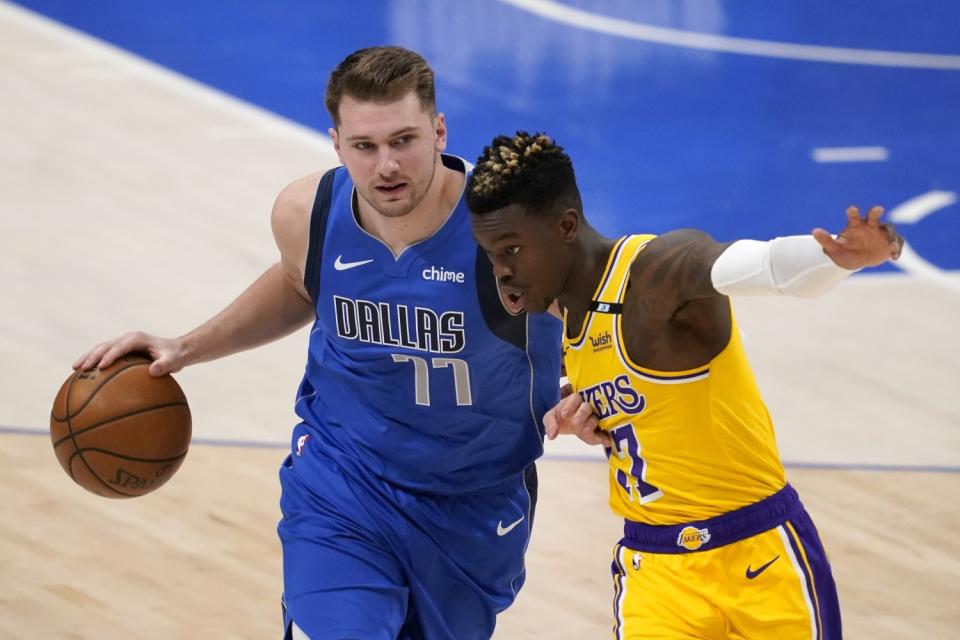 Dallas Mavericks' Luka Doncic drives against Lakers' Dennis Schroder.