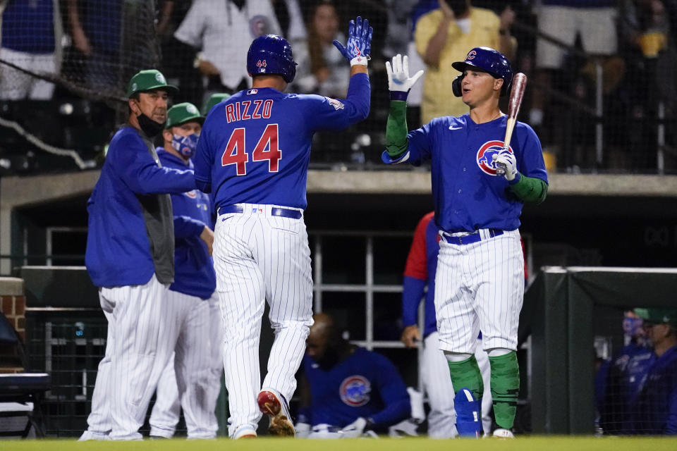 Chicago Cubs' Anthony Rizzo (44) high-fives Joc Pederson, right, after hitting a home run during the fourth inning of a spring training baseball game against the San Diego Padres Wednesday, March 17, 2021, in Mesa, Ariz. (AP Photo/Ashley Landis)