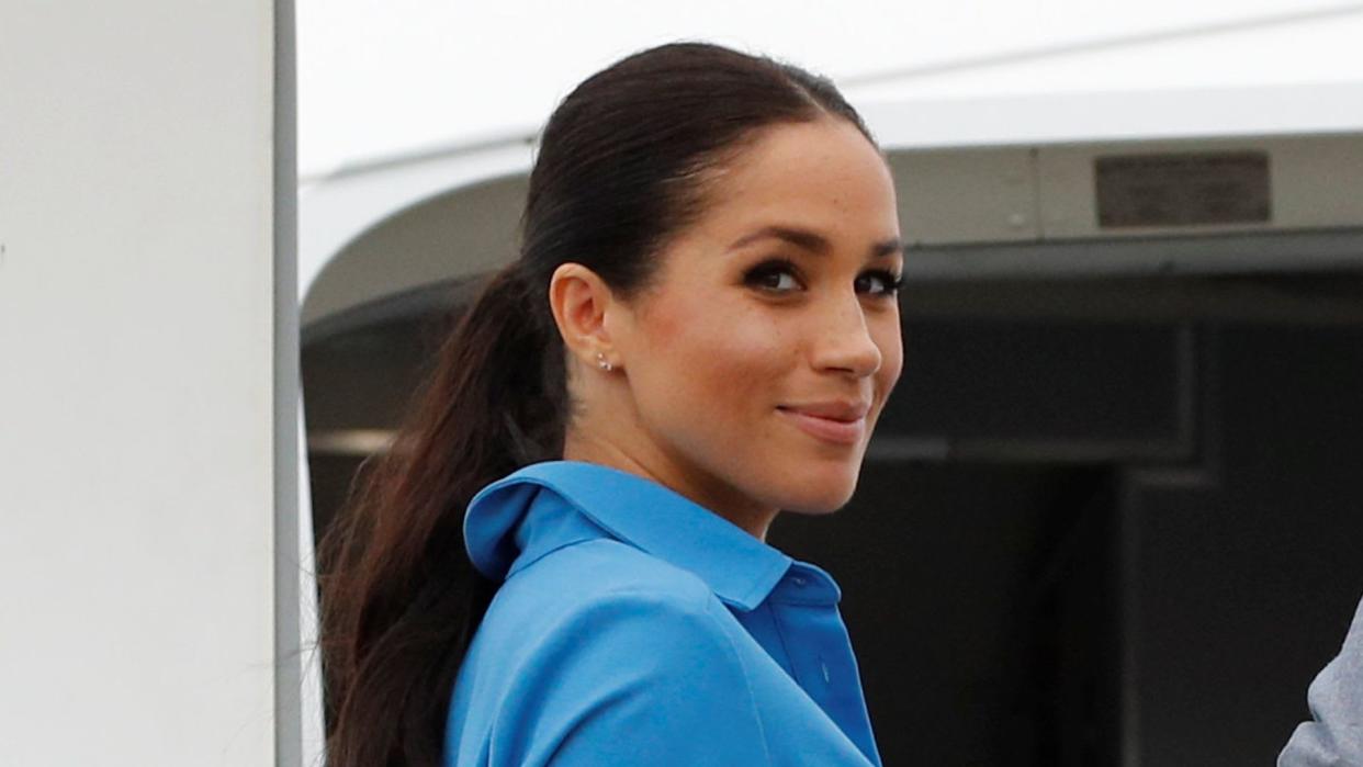 Prince Harry, Duke of Sussex and Meghan, Duchess of Sussex walk together, ahead of Tonga's Princess Angelika, as they depart from Fua'amotu International Airport on October 26, 2018 in Fua'amotu, Tonga.