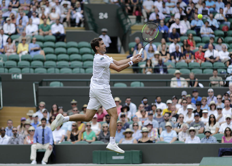 Argentina's Guido Pella returns the ball to Spain's Roberto Bautista Agut during a men's quarterfinal match on day nine of the Wimbledon Tennis Championships in London, Wednesday, July 10, 2019. (AP Photo/Ben Curtis)