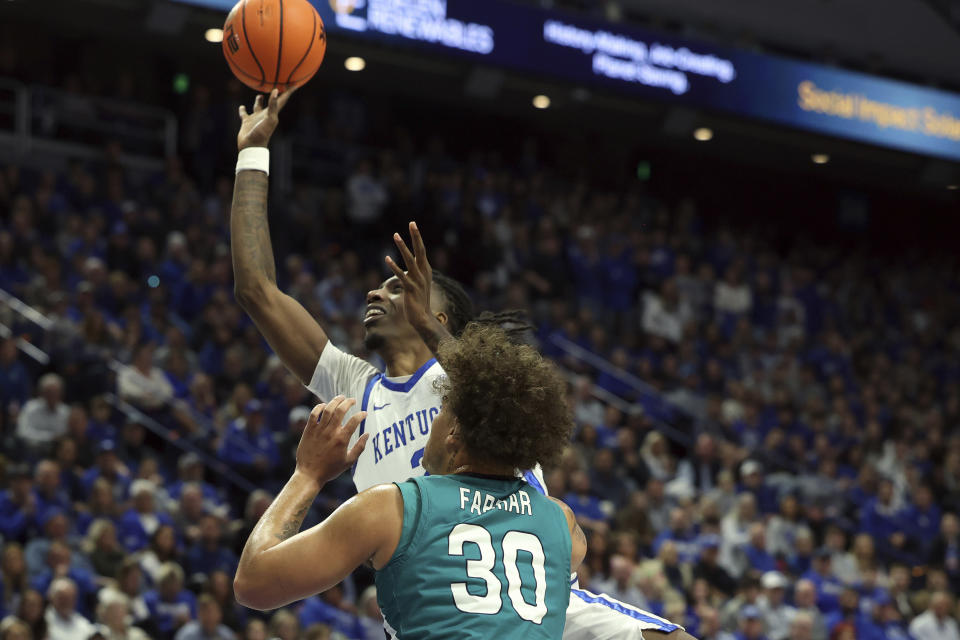 Kentucky's Aaron Bradshaw, top, shoots over UNC Wilmington's Nick Farrar (30) during the first half of an NCAA college basketball game in Lexington, Ky., Saturday, Dec. 2, 2023. (AP Photo/James Crisp)