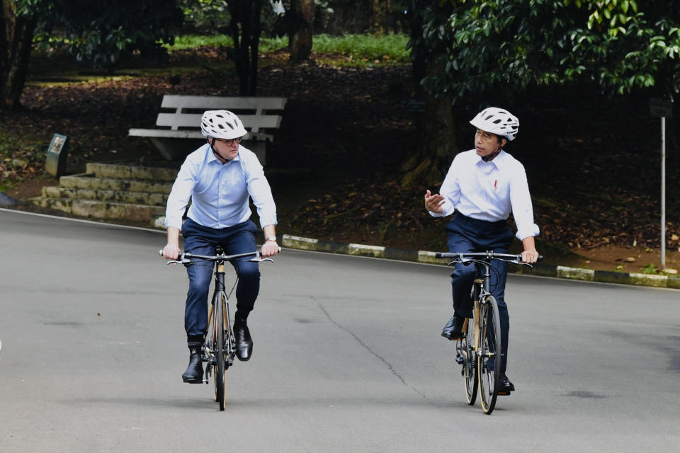 In this photo released by Indonesian Presidential Palace, Indonesian President Joko Widodo, right, talks with Australian Prime Minister Anthony Albanese as they ride their bicycles during their meeting at Bogor Palace in Bogor, Indonesia, Monday, June 6, 2022. Albanese on Monday looked to move beyond regional issues that have been a key part of his trips abroad by promoting the importance of building stronger economic ties with neighboring Indonesia. (Laily Rachev Indonesian Presidential Palace via AP)