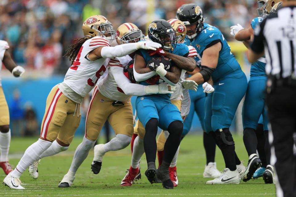 Jacksonville Jaguars running back Travis Etienne Jr. (1) is tackled by a host of San Francisco 49ers defenders during the first quarter of the Nov. 12 game at EverBank Stadium.