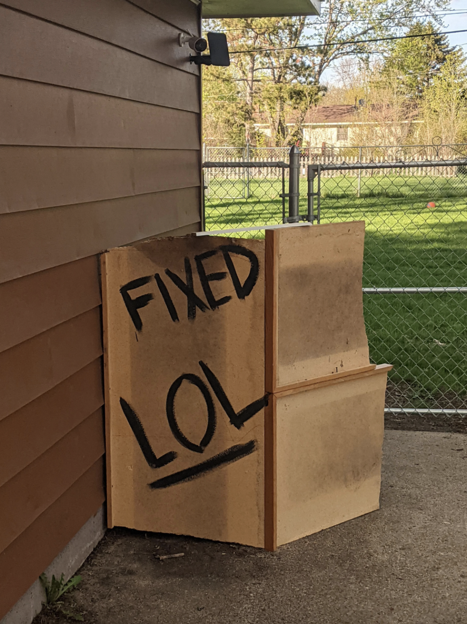 The trash cans are still in the same spot, but now have wood panels in front of them that say "fixed LOL"