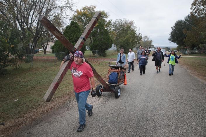 Worshipper Stephen Hope pulls a cross through Sutherland Springs after leaving the Sunday service (AFP Photo/SCOTT OLSON)