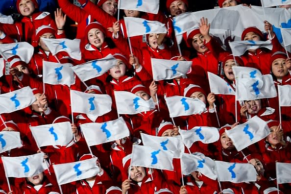 North Korean cheerleaders wave ‘unification flags’ ahead of the opening ceremony of the Pyeongchang 2018 Winter Olympic Games at the Pyeongchang Stadium on February 9, 2018. / AFP PHOTO / Martin BUREAU