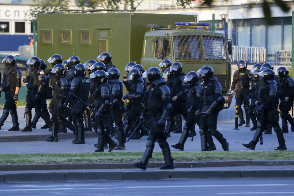 Police walk to push people away from a square during a mass protest following presidential elections in Minsk, Belarus, Monday, Aug. 10, 2020. Thousands of people have protested in Belarus for a second straight night after official results from weekend elections gave an overwhelming victory to authoritarian President Alexander Lukashenko, extending his 26-year rule. A heavy police contingent blocked central squares and avenues, moving quickly to disperse protesters and detained dozens. (AP Photo/Sergei Grits)