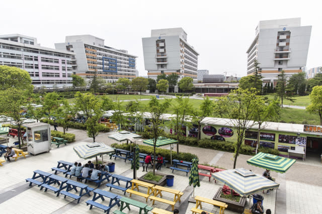 Employees relax and use their phones at an open air area during lunch break at a Pegatron Corp. factory in Shanghai, China, on Friday, April 15, 2016. This is the realm in which the world's most profitable smartphones are made, part of Apple Inc.'s closely guarded supply chain.Shanghai Factory Workers