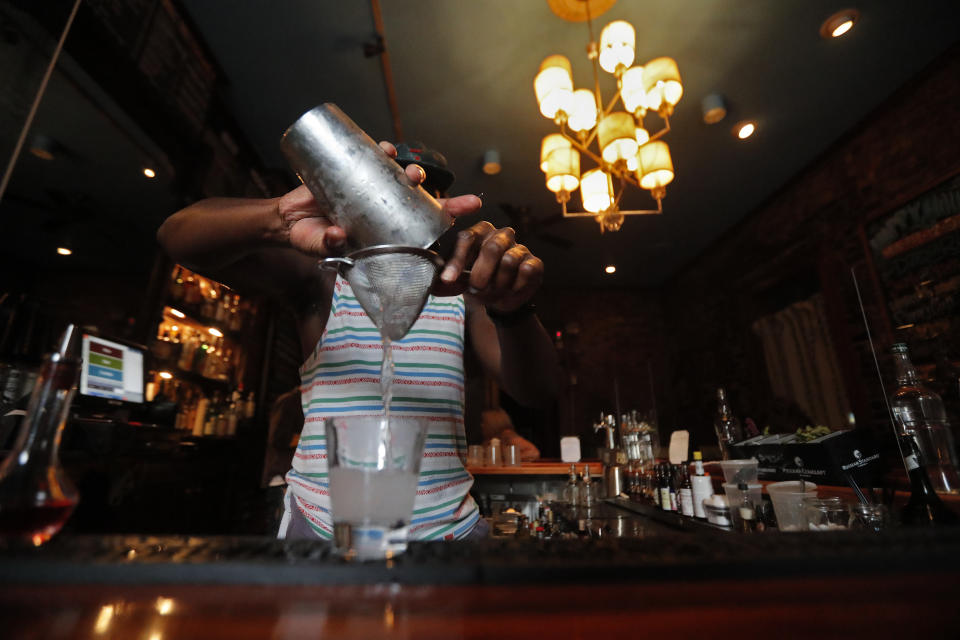 Bartender Brendan Donald makes cocktails inside Bar Tonique in New Orleans, Thursday, July 9, 2020. A sharp increase in COVID-19 cases and hospitalizations is forcing bars in the good-time-loving, tourist-dependent city to shut down again just a month after they were allowed to partially reopen. (AP Photo/Gerald Herbert)