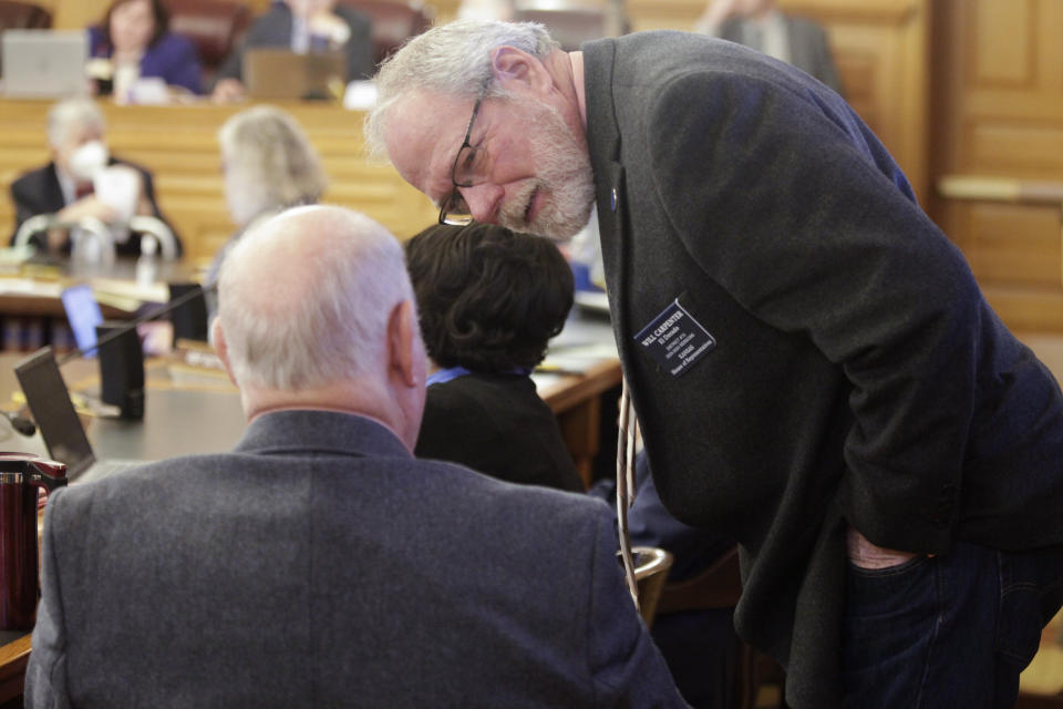 Kansas state Rep. Will Carpenter, R-El Dorado, confers with Rep. Ken Corbet, R-Topeka, during a joint meeting of the House and Senate budget committees, Thursday, Jan. 12, 2023, at the Statehouse in Topeka, Kansas. The committees had a briefing from Gov. Laura Kelly's budget director about her proposed $24.1 billion spending blueprint for the 2024 budget year that begins July 1, 2023. (AP Photo/John Hanna)