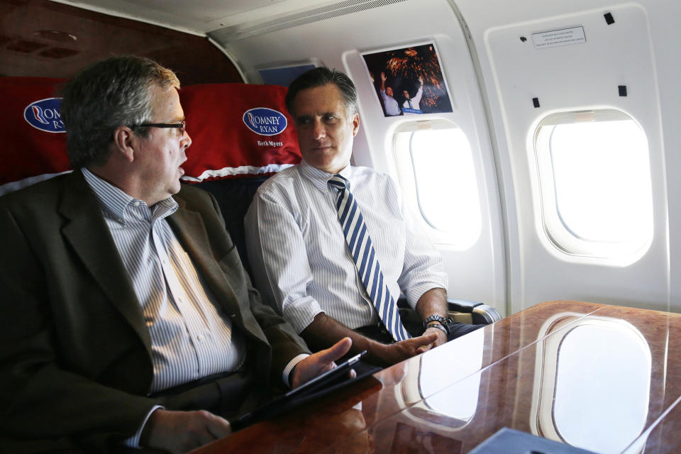 2012 Republican presidential candidate and former Massachusetts Gov. Mitt Romney is seated with former Florida Gov. Jeb Bush as they fly on Romney's campaign plane to Miami, Florida, on Wednesday, Oct. 31, 2012. (AP Photo/Charles Dharapak)