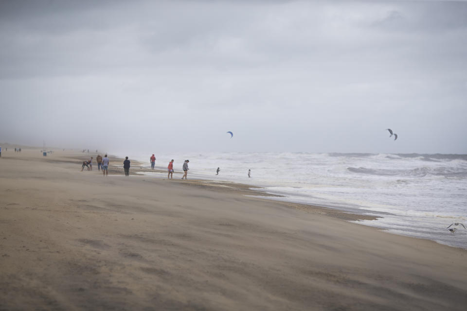 A group of beachgoers watch people kiteboarding in the storm surge of Tropical Storm Ophelia on Saturday, Sept. 23, 2023, at the Virginia Beach Oceanfront, in Virginia Beach, Va. (AP Photo/John C. Clark)