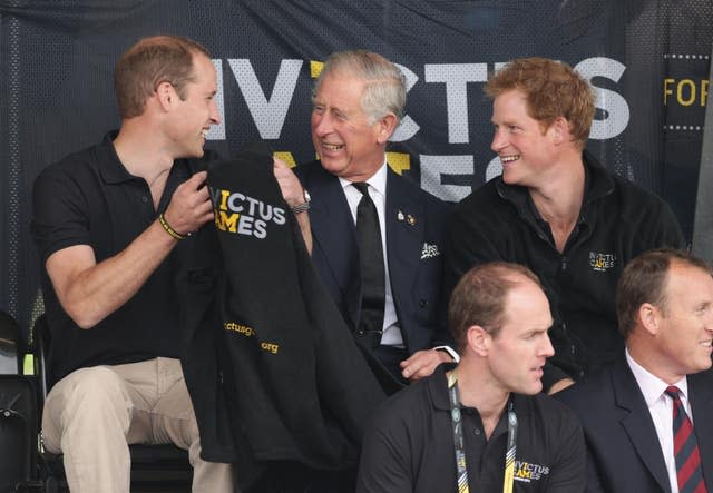 Charles sits in between William and Harry as they laugh together while attending the Invictus Games in 2014 