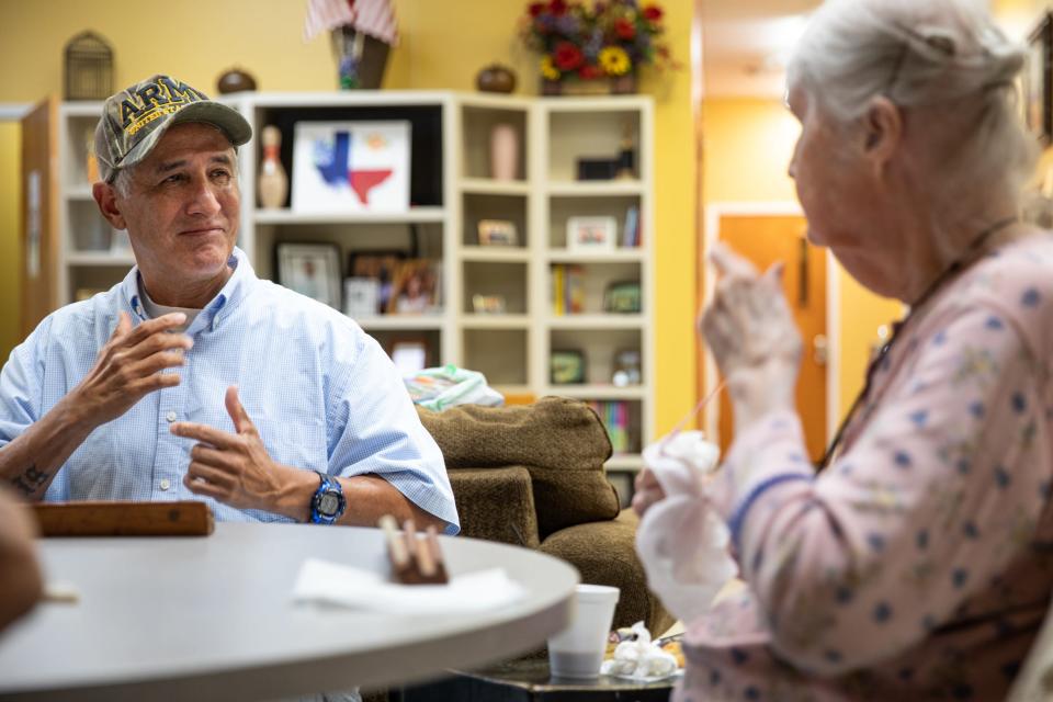 Aurelio Sirildo, 56, signs a conversation with Mary Mesmer, then 90, while playing Triominos at the Deaf and Hard of Hearing Center on Oct. 10, 2023, in Corpus Christi, Texas.