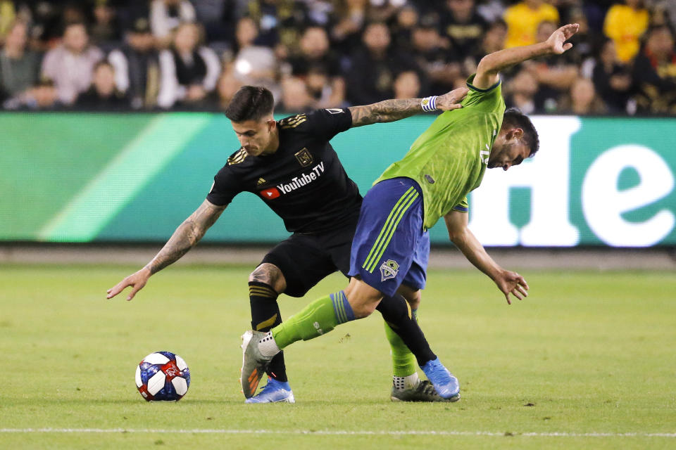 Los Angeles FC forward Brian Rodriguez, left, vies with Seattle Sounders midfielder Cristian Roldan for the ball during the first half of the MLS soccer Western Conference final, Tuesday, Oct. 29, 2019, in Los Angeles. (AP Photo/Ringo H.W. Chiu)