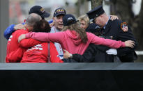 Visitors hug near a memorial pool at the National September 11 Memorial at the World Trade Center site in New York, Sunday, Sept. 11, 2011. (AP Photo/Seth Wenig, Pool)