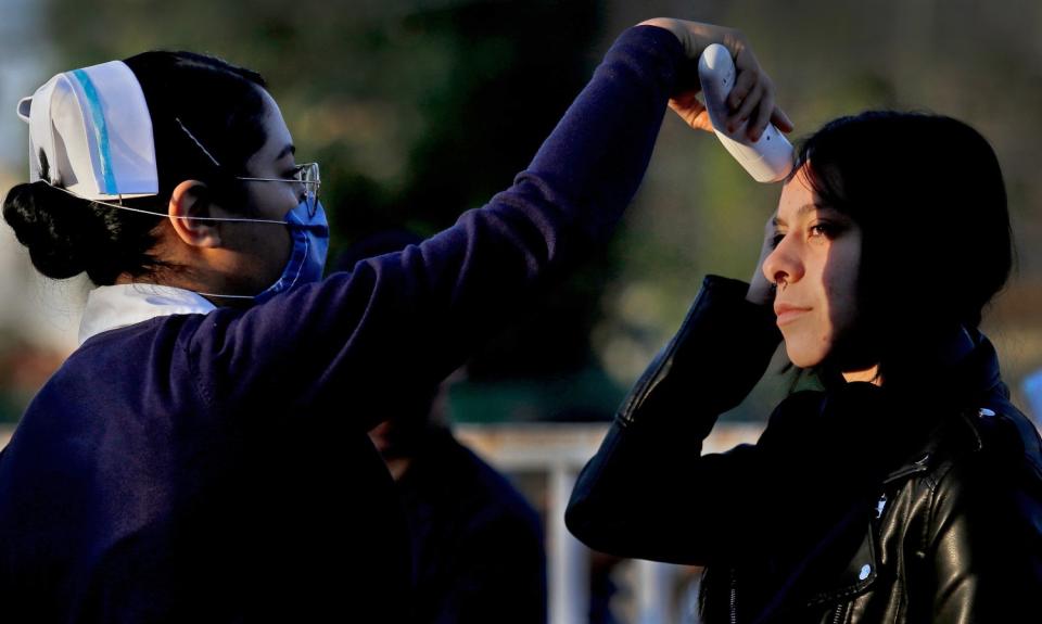 MEXICO: A nurse takes the temperature of a patient at the Jalisco Dermatological Institute in Guadalajara on March 13.