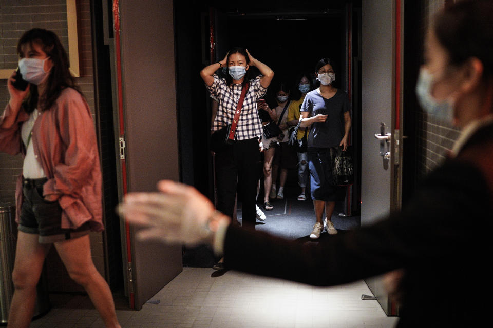 WUHAN, CHINA - JULY 20: (CHINA OUT)The employee wear the protective a mask while guides the audience through a passage to the exit in a cinema at Wuhan on July 20, 2020 in Wuhan ,Hubei Province,China.Taking various measures against COVID-19, cinemas in the city reopened in an orderly manner on Monday. The China Film Administration, in a circular last week, allowed cinemas in low-risk areas to resume operation with effective epidemic prevention measures in place. (Photo by Getty Images)