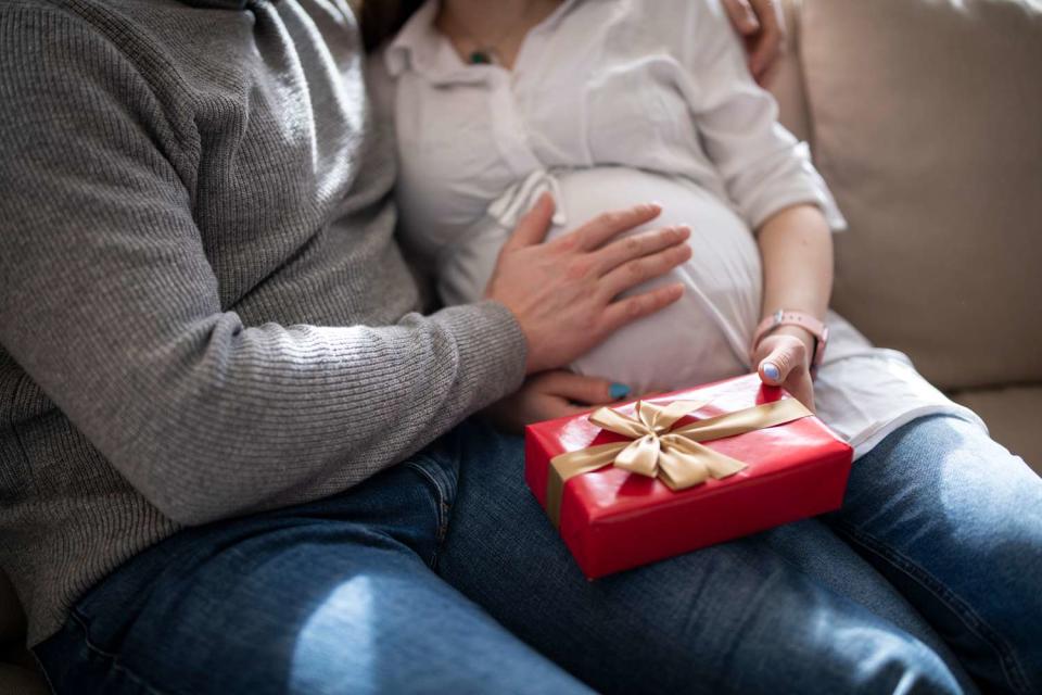 <p>Getty</p> Stock image of man giving his pregnant partner a gift