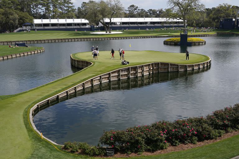 Dustin Johnson, a la derecha, práctica en el green del hoyo isla del 17 durante una ronda de práctica en The Players