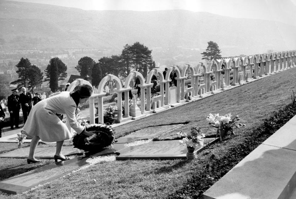<p>The Queen lays a wreath on 29 October 1966 in the Welsh village of Aberfan, where 116 children and 28 adults were killed after the collapse of a colliery spoil tip engulfed a school eight days earlier. The Queen's decision not to visit the village sooner is said to be her one big regret. (PA Images via Getty Images)</p> 
