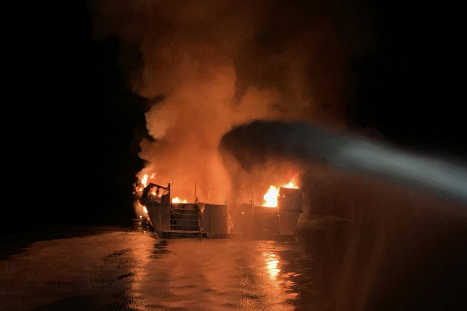 In this photo provided by the Ventura County Fire Department, VCFD firefighters respond to a boat fire off the coast of southern California, Monday, Sept. 2, 2019. The U.S. Coast Guard said it has launched several boats to help over two dozen people "in distress" off the coast of southern California. (Ventura County Fire Department via AP)