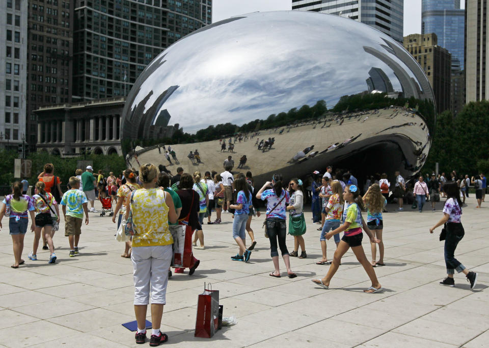 In this Wednesday, June 13, 2012, photo, visitors at Chicago's Millennium Park enjoy the sculpture "Cloud Gate," also known as "The Bean" on Wednesday, June 13, 2012 in Chicago. Millennium Park is one of several free activities/things/places visitors can enjoy in Chicago. (AP Photo/Charles Rex Arbogast)