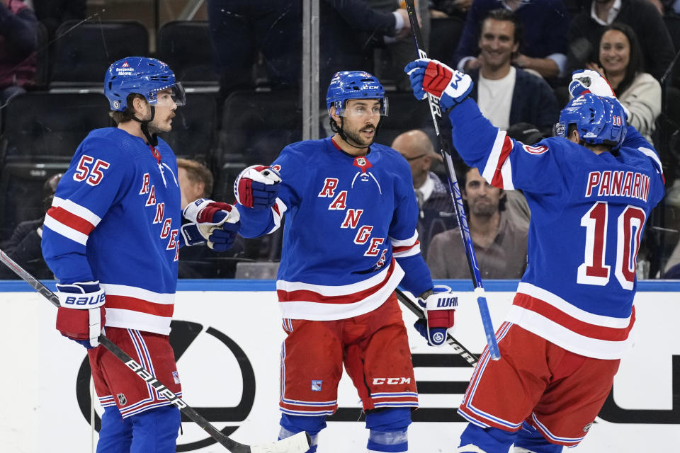 New York Rangers' Vincent Trocheck, center, celebrates with teammates Ryan Lindgren (55) and Artemi Panarin (10) after scoring a goal during the first period of an NHL hockey game against the Minnesota Wild, Thursday, Nov. 9, 2023, in New York. (AP Photo/Frank Franklin II)