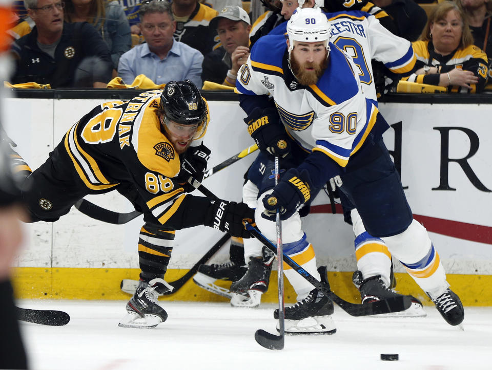 FILE - In this June 12, 2019, file photo, St. Louis Blues' Ryan O'Reilly (90) moves the puck away from Boston Bruins' David Pastrnak, left, of the Czech Republic, during the second period in Game 7 of the NHL hockey Stanley Cup Final, in Boston. O’Reilly stockpiled quite the hardware to show off at his Stanley Cup day. On display next to the Cup he helped the St. Louis Blues win were the Conn Smythe Trophy as playoff MVP and the Selke Trophy as the NHL’s best defensive forward. (AP Photo/Michael Dwyer)