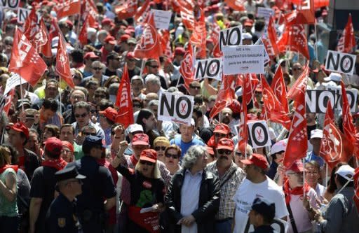 Members of the CCOO Workers Union and the General Union of Workers (UGT) wave banners during a protest against austerity measures at the Plaza de las Cortes in Madrid