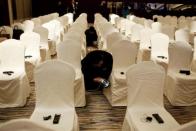 Employees use irons on chair covers before a Louis Vuitton's news conference in Shanghai, July 18, 2012.