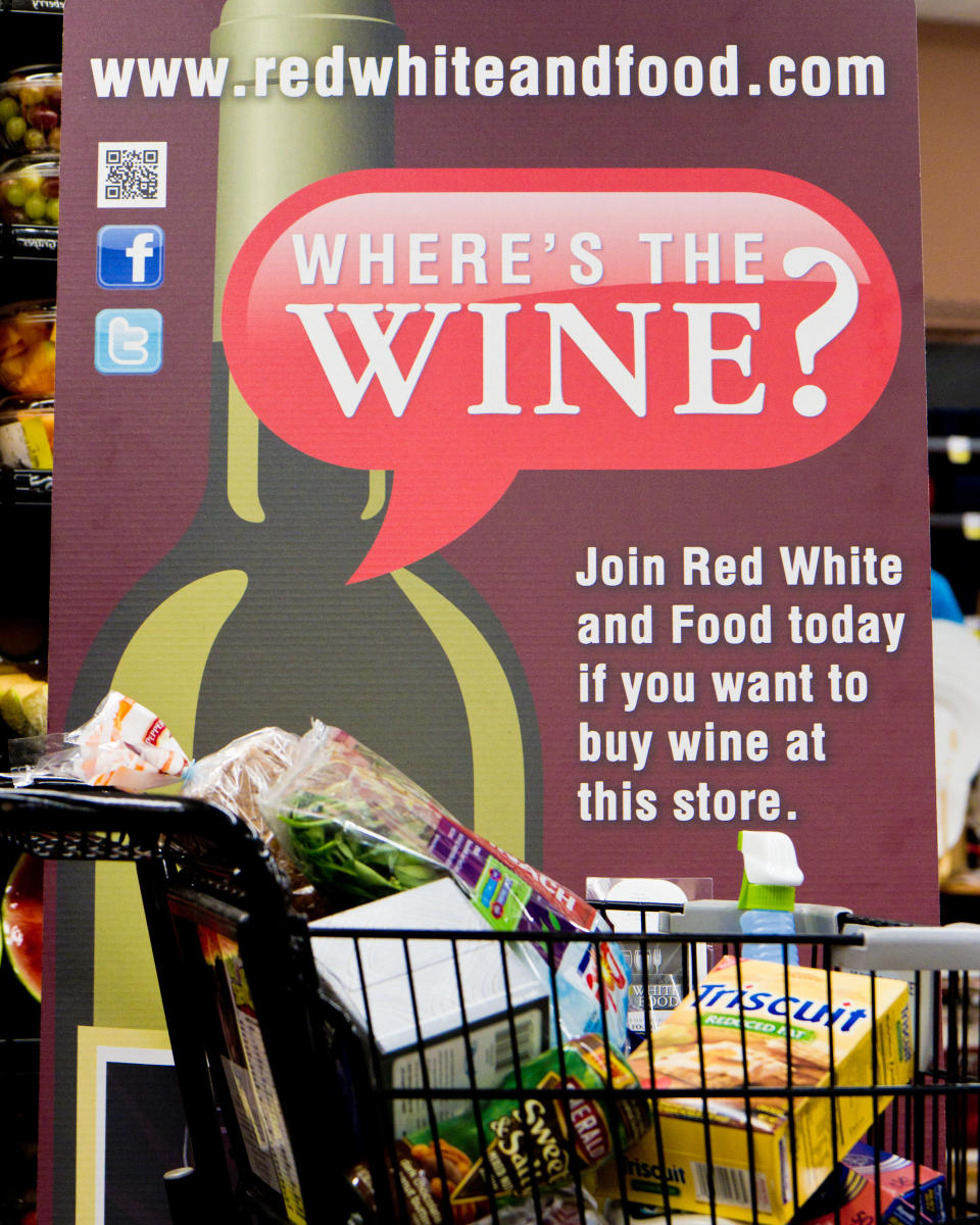 In this Friday, Nov. 30, 2012 photo, a sign in a Kroger supermarket in Nashville, Tenn., urges shoppers to sign up for a group urging lawmakers to change state law that limits wine sales to liquor stores. (AP Photo/Erik Schelzig)