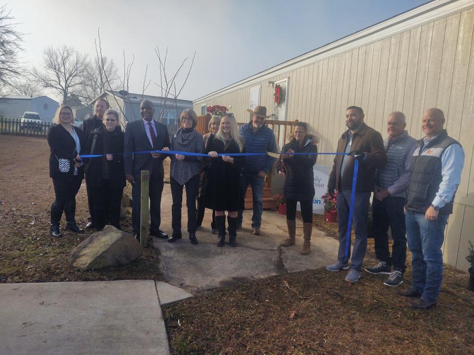 Representatives with Clayton Homes and Family Promise of Grayson County cut a ribbon for the non-profit's new transitional home for families working their way out of homelessness.